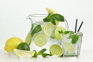 Ice lemonade with lemon, lime and mint on white background