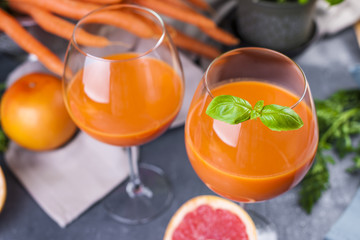 Juice from fresh carrots and basil in a glass, vitamin drink for a healthy diet. Copy space.