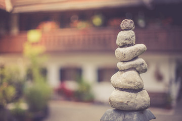 Steinmännchen mit unscharfen Bauernhaus im Hintergrund, Wellness Urlaub