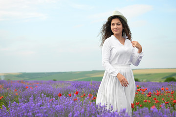 Fototapeta na wymiar young girl is in the lavender field, beautiful summer landscape with flowers