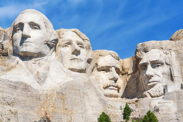 Closeup of presidential sculpture at Mount Rushmore national memorial, USA. Blue sky background.