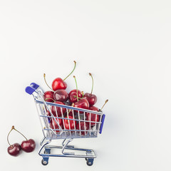 Ripe cherries in a shopping cart isolated