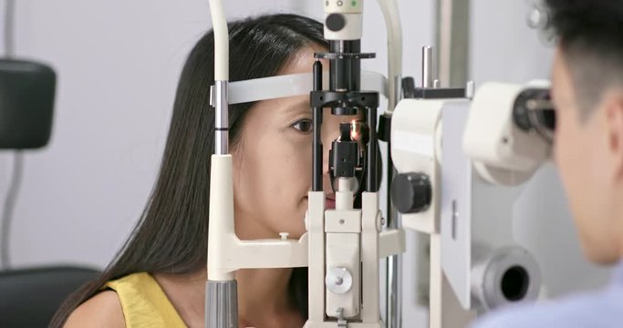 Woman checking on eye in clinic