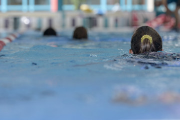 Blurred. Group of Children learn to swim in the pool