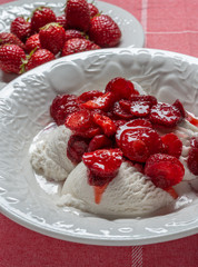 Bowl of vanilla ice cream covered with fresh strawberry sauce