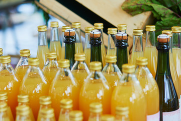 Bottles with apple juice and cider on farmer market