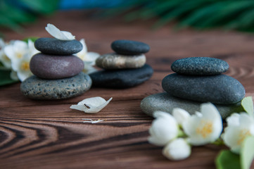 Pyramids of gray zen stones with beautiful fresh white flowers. Concept of harmony, balance and meditation, spa, massage, relax