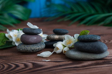 Pyramids of gray zen stones with beautiful fresh white flowers. Concept of harmony, balance and meditation, spa, massage, relax