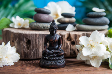 Obraz na płótnie Canvas Zen: Pyramids of gray zen stones with beautiful fresh white flowers and Buddha statue. Concept of harmony, balance and meditation, spa, massage, relax