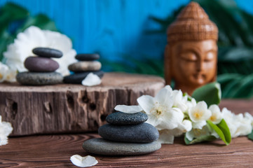 Zen:  Pyramids of gray zen stones with beautiful fresh white flowers and Buddha statue. Concept of harmony, balance and meditation, spa, massage, relax