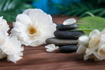 Naklejka na ściany i meble Pyramids of gray zen stones with beautiful fresh white flowers. Concept of harmony, balance and meditation, spa, massage, relax