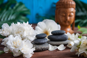 Zen:  Pyramids of gray zen stones with beautiful fresh white flowers and Buddha statue. Concept of...