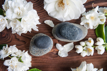 Fototapeta na wymiar Pyramids of gray zen stones with beautiful fresh white flowers. Concept of harmony, balance and meditation, spa, massage, relax