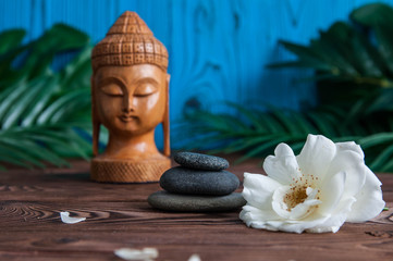 Zen:  Pyramids of gray zen stones with beautiful fresh white flowers and Buddha statue. Concept of harmony, balance and meditation, spa, massage, relax