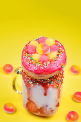 Freakshake. Extreme milkshake with strawberry, jelly sweets, donut.