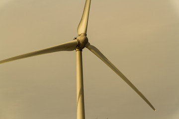 Wind turbine, against afternoon sky.