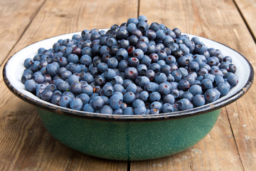 Fresh Bilberries from a bowl on old wooden table. Blueberries
