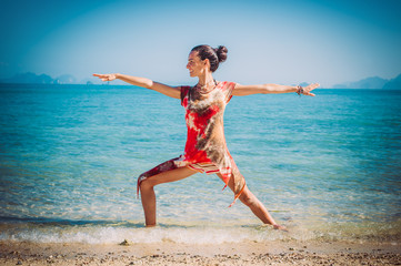Fit woman relaxing and practicing yoga outdoors by the sea