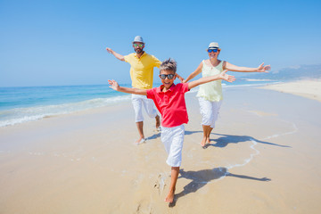 Family having fun and running on a sandy beach