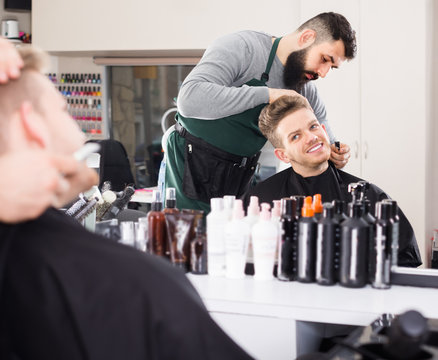 Man hairdresser making haircut to client