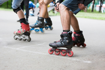 Close-up a legs group of men in roller skates are getting ready for the start in competitions on running rollers. Race on the rollerdrome. Roller on the road