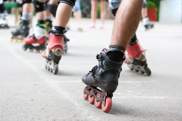 Close-up a legs group of men in roller skates are getting ready for the start in competitions on running rollers. Race on the rollerdrome. Roller on the road