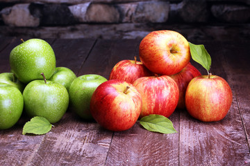 Ripe red apples and green apple on wooden background