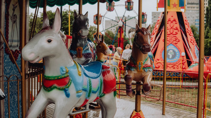 Outdoor colourful vintage flying horse carousel in the park
