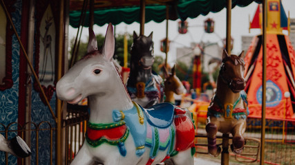 Outdoor colourful vintage flying horse carousel in the park