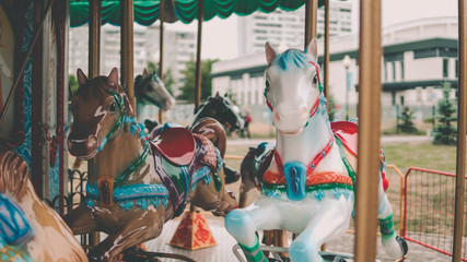 Outdoor colourful vintage flying horse carousel in the park