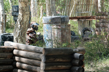 Mask, weapons, camouflage from the player during the game of paintball. Waiting for the enemy in...
