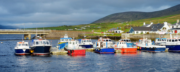 Colorful fishing boats and yachts at the harbor of Portmagee town on the West Atlantic coast of Ireland.