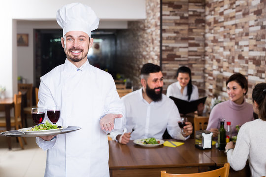 friendly male cook showing country restaurant