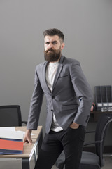 Confident businessman at working place. Bearded man in casual suit in office. Man with beard and mustache on serious face. Business and office lifestyle. Confidence and success concept