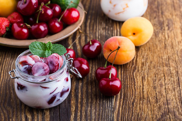 Healthy breakfast with sweet cherry yogurt and fresh  summer fruits