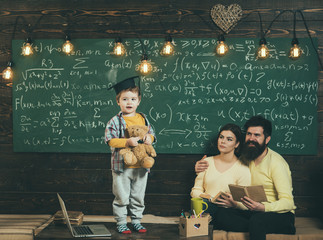 Support concept. Kid holds teddy bear and performing. Boy presenting his knowledge to mom and dad....