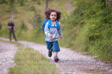 Kid running with daypack along hiking trail