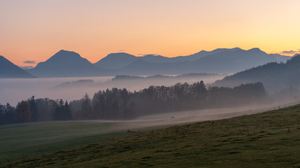 Upper bavarian mountain landscape with mist at sunset