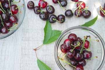 Spelled cherries on the white wooden background