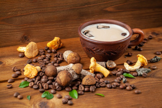 Concept of trend modern food industry. Mushroom coffee from mushrooms Chaga, a ceramic cup on a wooden background with coffee beans. Cappuccino, hipster, latte, instagram. Copy space, selective focus.