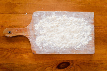 Top side view on white flour on rustic wooden table background, closeup of healthy cooking copyspace surface at home, restaurant, fabric plant