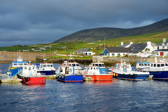 Colorful fishing boats and yachts at the harbor of Portmagee town on the West Atlantic coast of Ireland.