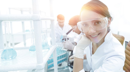 Investigator checking test tubes, Woman wears protective goggles