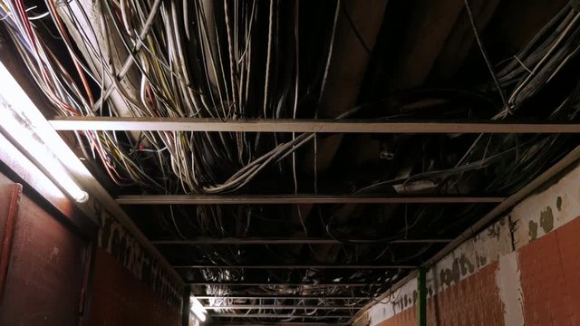 Ceiling pipe and wires in an abandoned building in the dark.