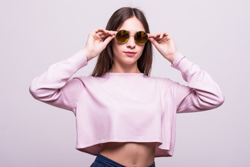 Beautiful fashion woman wearing sunglasses over a white background