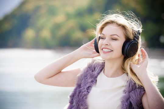 Happy woman wearing headphones outdoor