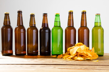 Beer bottles on a wooden table . Potato chips. Top view. Selective focus. Mock up. Copy...