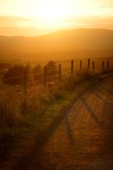 Beautiful sunset in Connemara. Scenic countryside road leading towards magnificent mountains, County Galway, Ireland.