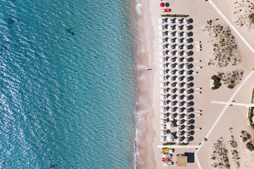 Aerial view of amazing seaside resort with turquoise sea. White umbrellas and sun loungers. Beautiful sunny summer day in Sardinia,Mediterranean sea, Italy..