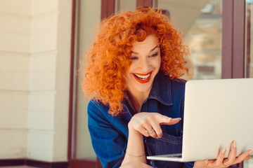 woman looking pointing with finger at her computer